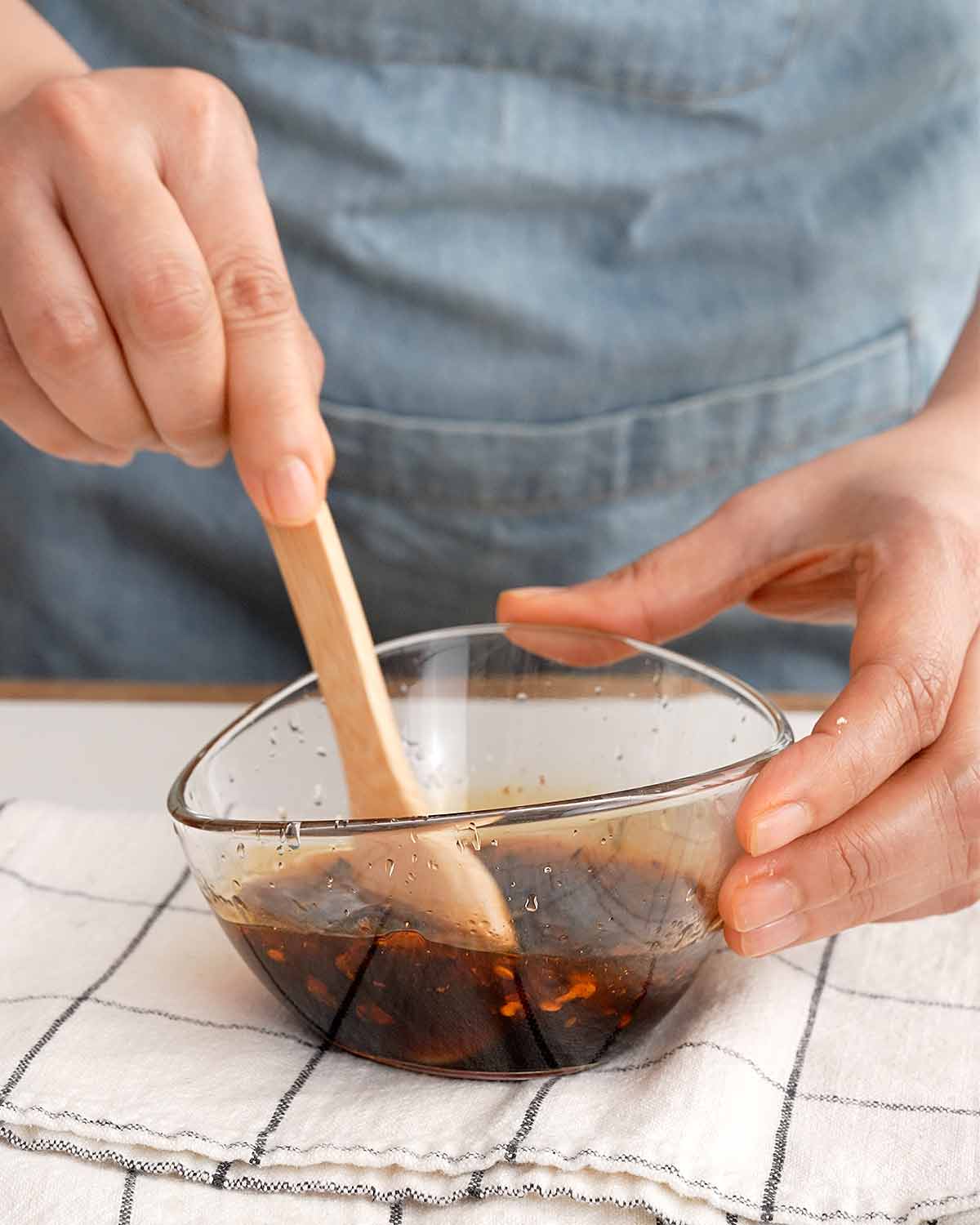 An image showing mixing a dressing sauce in a small glass bowl.
