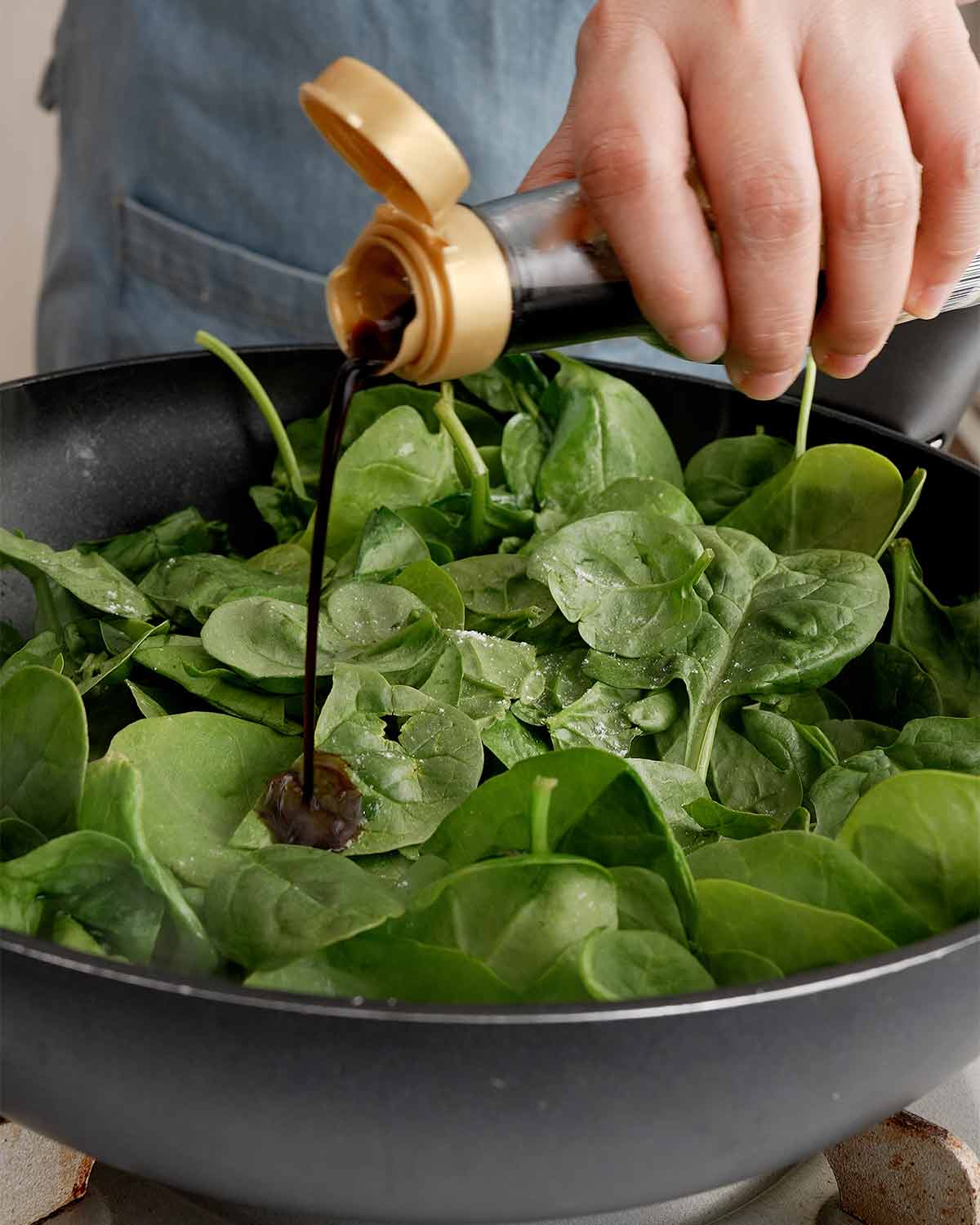 Adding seasonings to the spinach.